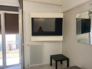 Una sala de estar con un televisor de pantalla plana en una pared. en casa sui sassi A, en Matera