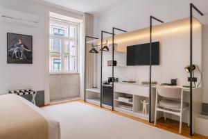 a bedroom with a bed and a desk and a tv at Rosário Suites Townhouse in Porto