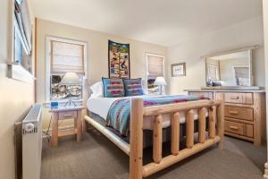 a bedroom with a bed and a desk and a mirror at RMR: The Village House in Teton Village in Teton Village