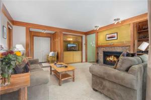 a living room with a couch and a fireplace at RMR: Teewinot A2 Condo in Teton Village in Teton Village