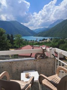 a table and chairs on a balcony with a view of a lake at Apartment ONE in Plužine
