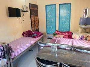 three empty beds in a room with a sink at Ma manasha lodge in Guwahati