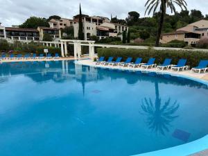 a large swimming pool with lounge chairs and a resort at Elomarisa in Grimaud