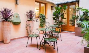a patio with a table and chairs and plants at Dimora del Mercante - Luxury rooms in Florence +42 photos