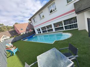 a backyard with a swimming pool and a house at Hotel ARBOR - Les Hunaudieres - Le Mans Sud - Mulsanne in Mulsanne
