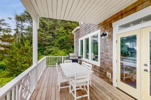 a wooden deck with a table and chairs on it at The Bellevue in Lincoln City