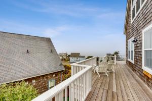 a wooden deck with two chairs on a house at The Bellevue in Lincoln City