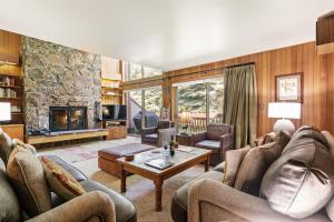 a living room with couches and a stone fireplace at RMR: Wind River 5 Condo in Teton Village in Teton Village