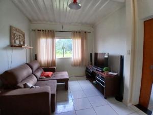 een woonkamer met een bank en een tv bij Ana Terra Barretos Casa de Campo in Barretos
