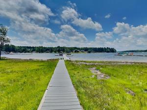 a walkway leading into a river with boats in the water at Paravel in Swanton