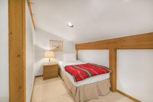 une chambre avec un lit avec une couverture rouge dans l'établissement RMR: Geranium 2621 Condo in The AspensWilsonWY, à Wilson