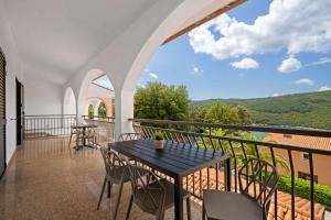 eine Terrasse mit Tisch und Stühlen auf einem Balkon in der Unterkunft Apartment Rabac 12 in Rabac