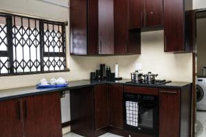 a kitchen with wooden cabinets and a stove top oven at Tshukudu e Ntsho in Mogwase