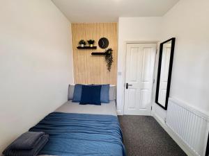 a small bedroom with a blue bed and a door at Convenient Private Single Room 30 Min to Central in Wembley