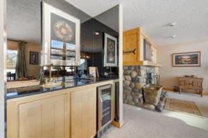 una cucina con lavandino e camino in pietra di RMR: Greyling 4513 Condo in The AspensWilsonWY a Wilson