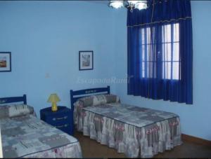 a bedroom with two beds and a blue wall at Casa Rural La Morateña in Morata de Tajuña +6 photos