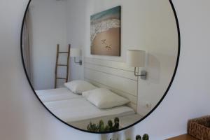 a mirror reflecting two beds in a room at Aegeo Inn in Antiparos