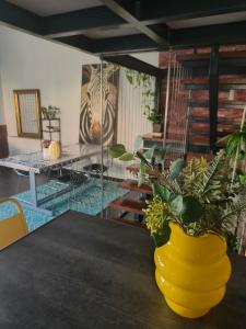 eine gelbe Vase auf einem Tisch mit einer Pflanze in der Unterkunft ColoR Living - loft & yard in Kardítsa