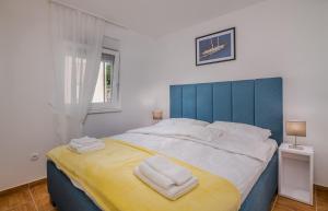 a bedroom with a large bed with towels on it at Apartment TRIES 1 with heated pool and sea view in Klimno