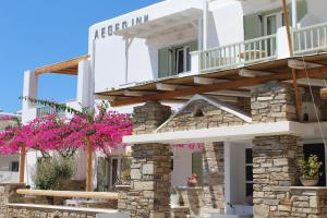 a white building with pink flowers in front of it at Aegeo Inn in Antiparos