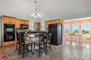 a kitchen with a black refrigerator and a table with chairs at Tees & Tides in Nags Head