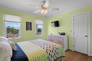 a bedroom with a bed and a ceiling fan at Tees & Tides in Nags Head