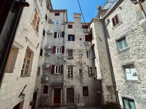 ein altes Steingebäude mit roten Türen und Fenstern in der Unterkunft sar 3 in Kotor
