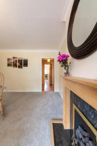a living room with a fireplace and a mirror at Stag's View Lodge in Edinburgh