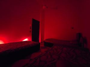 Habitación con 2 camas en una habitación de color rojo. en Golden home, en Asuán
