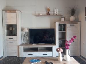 a living room with a entertainment center with a television at Elmar House in Paralio Astros
