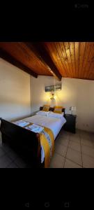 a bedroom with two beds and a wooden ceiling at restaurant japonais Tokogine chambre d hote in Listrac-Médoc