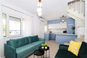 a living room with a blue couch and a kitchen at Harmony Sea House Hanioti 4 bedrooms 10 guests in Hanioti