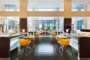 a restaurant with yellow chairs and tables in a building at Ibis Al Rigga in Dubai