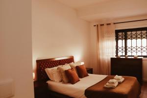 une chambre avec un lit avec des oreillers et une fenêtre dans l'établissement Casinha da Praia - Vila Nova de Gaia, à Vila Nova de Gaia