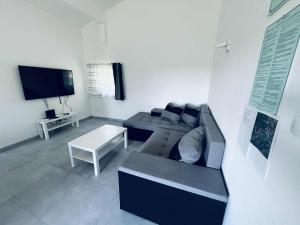 a living room with a couch and a table at Gádé Apartmanház in Sukoró