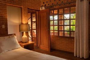 a bedroom with a bed and a brick wall at David's Den Atitlán in Panajachel