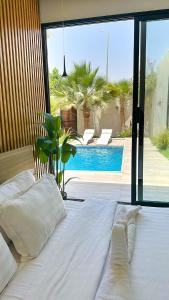 a bedroom with a large bed and a swimming pool at شاليه فندقي غرفتين نوم مسبح وبانيو in Banī Ma‘n