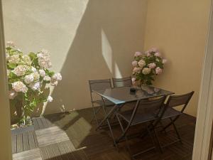 a table and chairs with flowers in a room at Villa Estelle et villa Jean, ensemble de 2 villas Wimereusienne in Wimereux