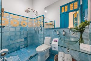 a blue tiled bathroom with a toilet and a sink at Hotel Boutique Fundadores en Cauca Viejo in Jericó