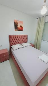 a bedroom with a large bed with a red headboard at Rouge Azur Saidia in Saïdia