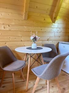 a table with three chairs and a vase of flowers at Valley Nest in Virpazar