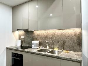 a kitchen with a sink and white cabinets at Bonded in Hanoi