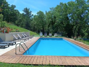 a swimming pool with chairs and a wooden deck at Mas Auroma in Murs