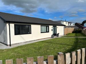 a white house with a fence in front of it at Thirlmere View Helmshore in Haslingden