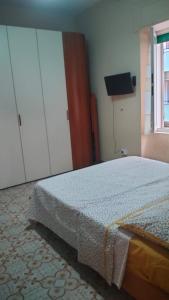 カステッランマーレ・ディ・スタービアにあるCasa Vacanze Tondo Tondoのベッドとドレッサーと窓のある寝室