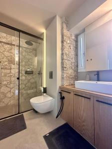 a bathroom with a toilet and a sink and a shower at Linen by Goutos Luxury Living in Kranidi