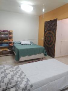 a bedroom with two beds and a wall with a closet at kitnet Silva Guedes in São Thomé das Letras +2 photos