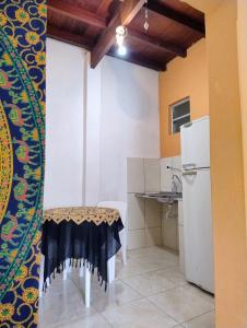 a small kitchen with a table and a refrigerator at kitnet Silva Guedes in São Thomé das Letras