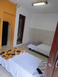 a room with two beds in a room at kitnet Silva Guedes in São Thomé das Letras