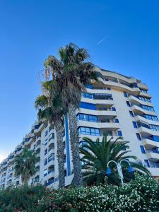 two palm trees in front of a building at Beachfront Family Appartment with Pool in Valencia